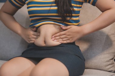 Şişman karnına dokunup sıkarken çekilmiş bir fotoğraf..