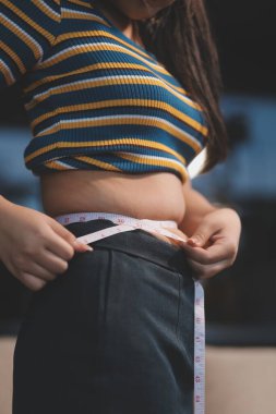 Şişman karnına dokunup sıkarken çekilmiş bir fotoğraf..