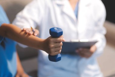 Tanımlanamayan fiziksel terapi sırasında mavi el ağırlığı kullanır