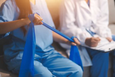 Erkek bir hasta üzerinde egzersiz band klinikte rehabilitasyon fizyoterapi kavramı ile onun kol germe egzersiz tedavisi verirken yardımcı doktor fizyoterapist