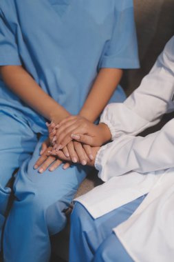 Görüntüleri kapatın, doktor hastaya tavsiye vermek ve hastalıkla mücadeleyi teşvik etmek için el ele tutuşuyor ve yaşlı hastalara ve sağlık hizmetleri konseptine destek oluyor..