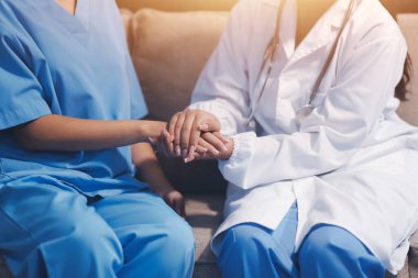 Görüntüleri kapatın, doktor hastaya tavsiye vermek ve hastalıkla mücadeleyi teşvik etmek için el ele tutuşuyor ve yaşlı hastalara ve sağlık hizmetleri konseptine destek oluyor..