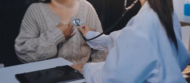 Doktor, solunum sistemini ve yaşlı hastalar için konsültasyonları inceleyen steteskop kullanın, sağlık kontrolü ya da test sonuçlarını paylaşın