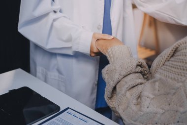 Doktor eli, kadın hastasına güven veriyor.