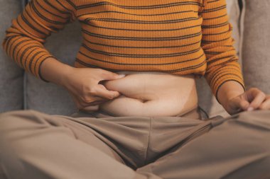 Şişman karnına dokunup sıkarken çekilmiş bir fotoğraf..