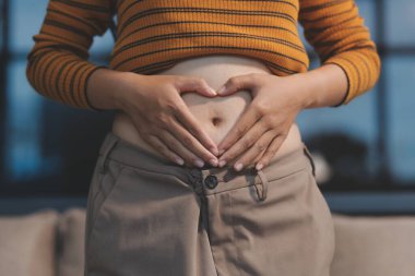 Şişman karnına dokunup sıkarken çekilmiş bir fotoğraf..