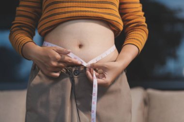 Şişman karnına dokunup sıkarken çekilmiş bir fotoğraf..