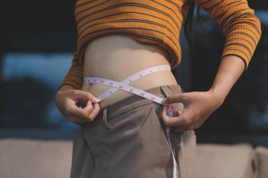 Şişman karnına dokunup sıkarken çekilmiş bir fotoğraf..