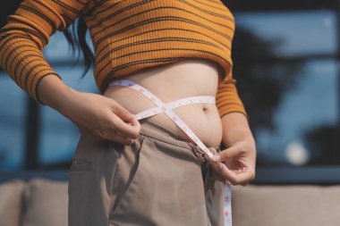 Şişman karnına dokunup sıkarken çekilmiş bir fotoğraf..