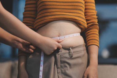 Şişman karnına dokunup sıkarken çekilmiş bir fotoğraf..