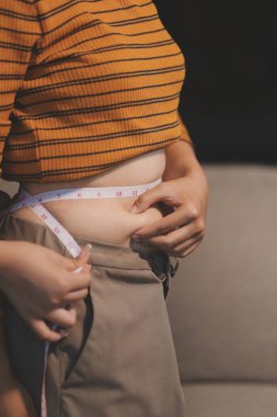 Şişman karnına dokunup sıkarken çekilmiş bir fotoğraf..