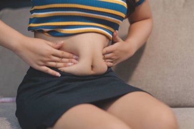 Şişman karnına dokunup sıkarken çekilmiş bir fotoğraf..