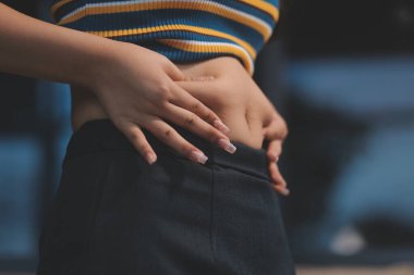 Şişman karnına dokunup sıkarken çekilmiş bir fotoğraf..