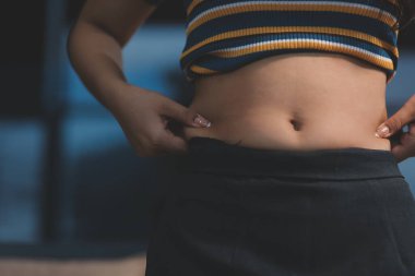 Şişman karnına dokunup sıkarken çekilmiş bir fotoğraf..