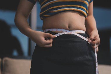 Şişman karnına dokunup sıkarken çekilmiş bir fotoğraf..