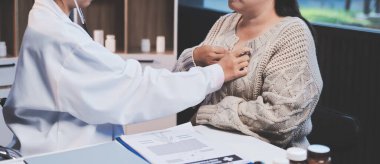 Doktor, solunum sistemini ve yaşlı hastalar için konsültasyonları inceleyen steteskop kullanın, sağlık kontrolü ya da test sonuçlarını paylaşın