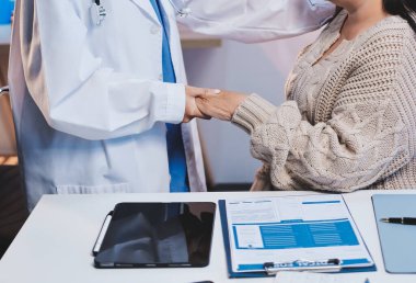 Doktor eli, kadın hastasına güven veriyor.