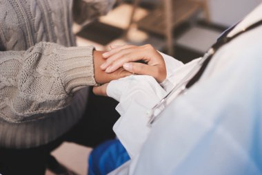 Doktor eli, kadın hastasına güven veriyor.