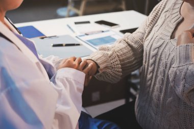 Doktor eli, kadın hastasına güven veriyor.