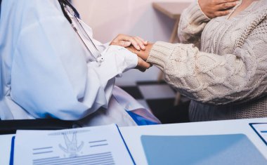 Doktor eli, kadın hastasına güven veriyor.