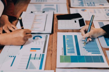 Bir grup iş adamı, analitik plan toplantısında beyin fırtınası yaparak grafikten elde edilen rakamları hesaplıyor. Finansal büyüme tablosu. Pazarlama. İş başarısı istatistikleri kavramı.