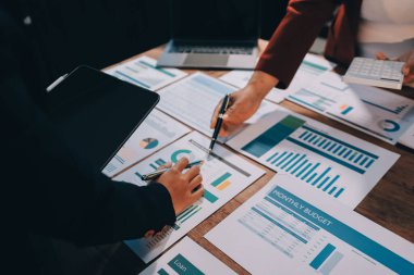 Bir grup iş adamı, analitik plan toplantısında beyin fırtınası yaparak grafikten elde edilen rakamları hesaplıyor. Finansal büyüme tablosu. Pazarlama. İş başarısı istatistikleri kavramı.