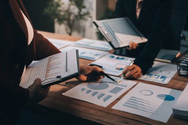 Bir grup iş adamı, analitik plan toplantısında beyin fırtınası yaparak grafikten elde edilen rakamları hesaplıyor. Finansal büyüme tablosu. Pazarlama. İş başarısı istatistikleri kavramı.