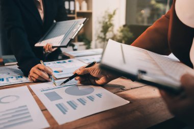 Bir grup iş adamı, analitik plan toplantısında beyin fırtınası yaparak grafikten elde edilen rakamları hesaplıyor. Finansal büyüme tablosu. Pazarlama. İş başarısı istatistikleri kavramı.