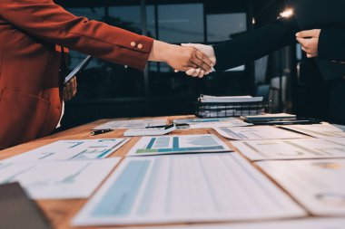 Genç işadamı ofiste iş kadınıyla el sıkışıyor.