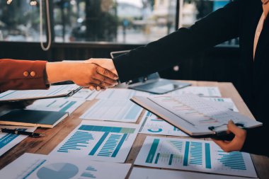 Ofis toplantısında iki farklı profesyonel iş adamı yönetici lider el sıkışıyor.