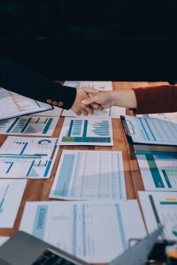 Ofis toplantısında iki farklı profesyonel iş adamı yönetici lider el sıkışıyor.