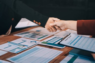 Ofis toplantısında iki farklı profesyonel iş adamı yönetici lider el sıkışıyor.