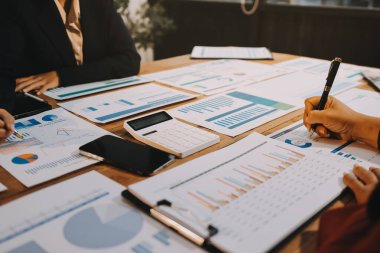 Bir grup iş adamı, analitik plan toplantısında beyin fırtınası yaparak grafikten elde edilen rakamları hesaplıyor. Finansal büyüme tablosu. Pazarlama. İş başarısı istatistikleri kavramı.