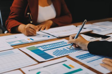 Bir grup iş adamı, analitik plan toplantısında beyin fırtınası yaparak grafikten elde edilen rakamları hesaplıyor. Finansal büyüme tablosu. Pazarlama. İş başarısı istatistikleri kavramı.