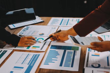 Bir grup iş adamı, analitik plan toplantısında beyin fırtınası yaparak grafikten elde edilen rakamları hesaplıyor. Finansal büyüme tablosu. Pazarlama. İş başarısı istatistikleri kavramı.