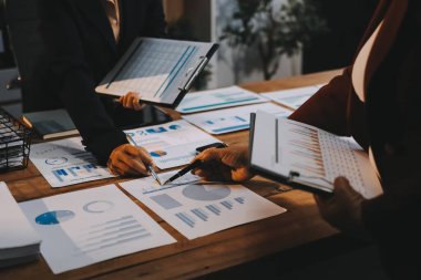 Bir grup iş adamı, analitik plan toplantısında beyin fırtınası yaparak grafikten elde edilen rakamları hesaplıyor. Finansal büyüme tablosu. Pazarlama. İş başarısı istatistikleri kavramı.