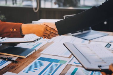 Ofis toplantısında iki farklı profesyonel iş adamı yönetici lider el sıkışıyor.