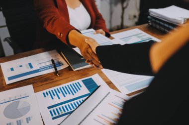 Ofis toplantısında iki farklı profesyonel iş adamı yönetici lider el sıkışıyor.