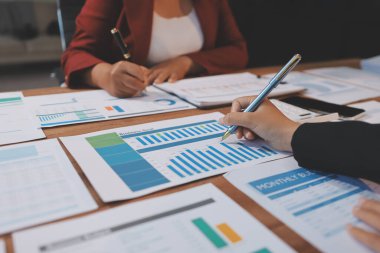 Bir grup iş adamı, analitik plan toplantısında beyin fırtınası yaparak grafikten elde edilen rakamları hesaplıyor. Finansal büyüme tablosu. Pazarlama. İş başarısı istatistikleri kavramı.