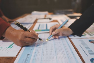 Bir grup iş adamı, analitik plan toplantısında beyin fırtınası yaparak grafikten elde edilen rakamları hesaplıyor. Finansal büyüme tablosu. Pazarlama. İş başarısı istatistikleri kavramı.