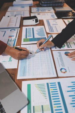 Bir grup iş adamı, analitik plan toplantısında beyin fırtınası yaparak grafikten elde edilen rakamları hesaplıyor. Finansal büyüme tablosu. Pazarlama. İş başarısı istatistikleri kavramı.