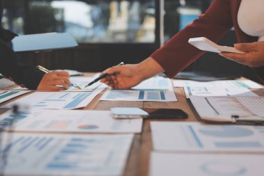 Bir grup iş adamı, analitik plan toplantısında beyin fırtınası yaparak grafikten elde edilen rakamları hesaplıyor. Finansal büyüme tablosu. Pazarlama. İş başarısı istatistikleri kavramı.