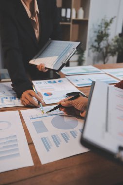 Bir grup iş adamı, analitik plan toplantısında beyin fırtınası yaparak grafikten elde edilen rakamları hesaplıyor. Finansal büyüme tablosu. Pazarlama. İş başarısı istatistikleri kavramı.