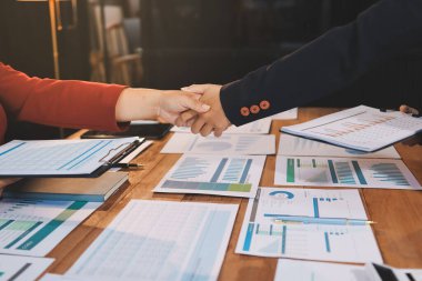 Ofis toplantısında iki farklı profesyonel iş adamı yönetici lider el sıkışıyor.