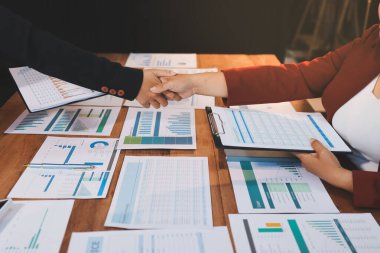 Ofis toplantısında iki farklı profesyonel iş adamı yönetici lider el sıkışıyor.