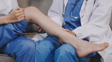 Doktor hastanın bacağını kontrol ediyor.