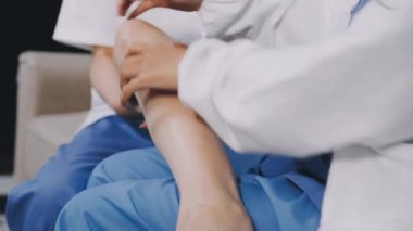Bir doktorun elini tutan kadının yakın çekimi.