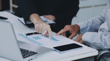 Ofisteki finansal veri ve dizüstü bilgisayarı analiz eden iş adamı.