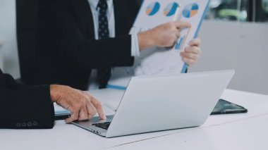 İşadamı dizüstü bilgisayar ve grafikle çalışıyor