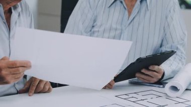 Ofisteki genç mimar. Mühendis elinde yeni bir plan tutuyor.